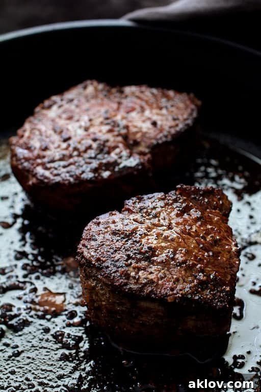 Another photo of two seared fillets in a cast iron skillet, ready to go into the oven.