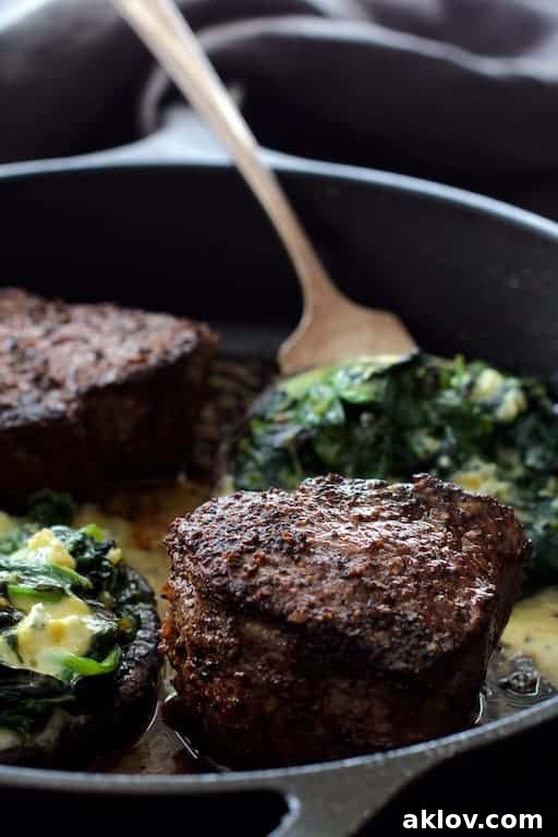 Process photo of Beef Tenderloin Fillets with Spinach Cambozola Stuffed Mushrooms being cooked together in cast iron skillet, showcasing the harmonious cooking.
