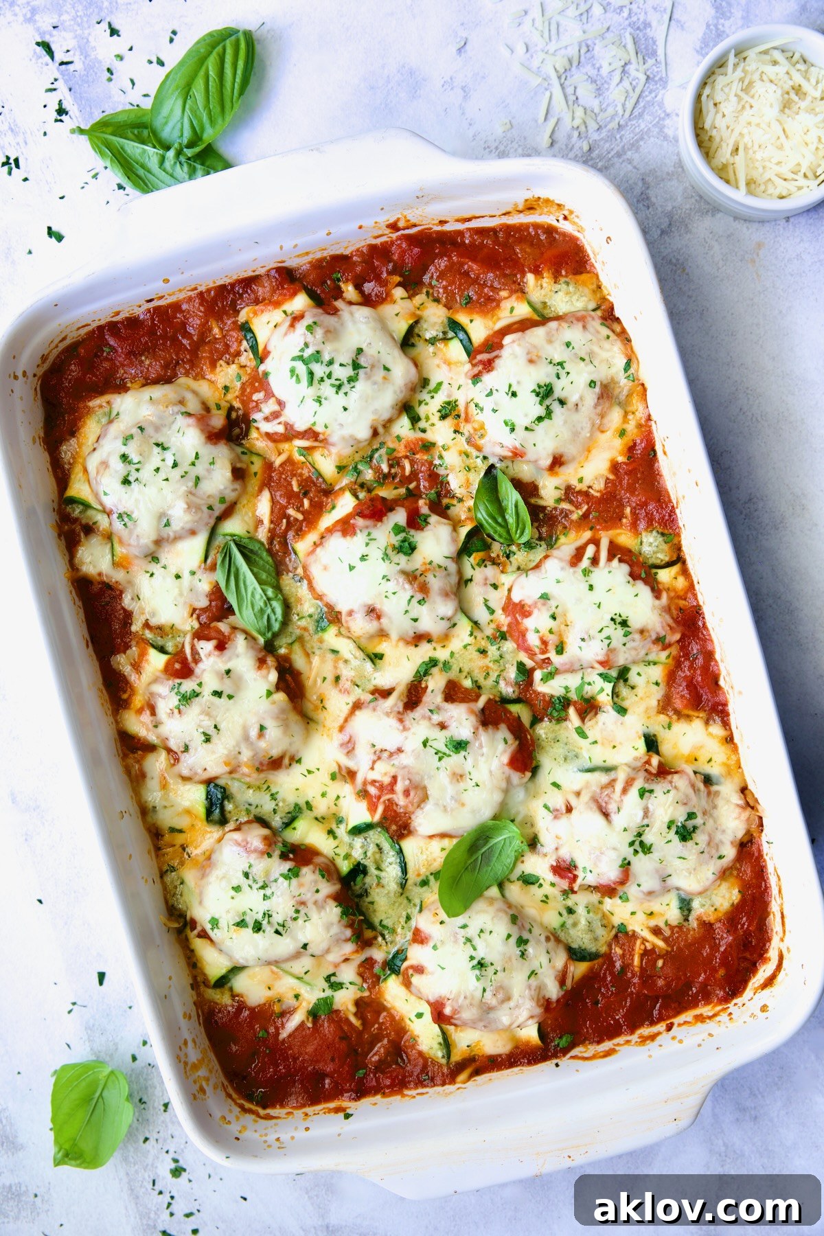 Zucchini Ravioli in white baking dish with serving spoon.