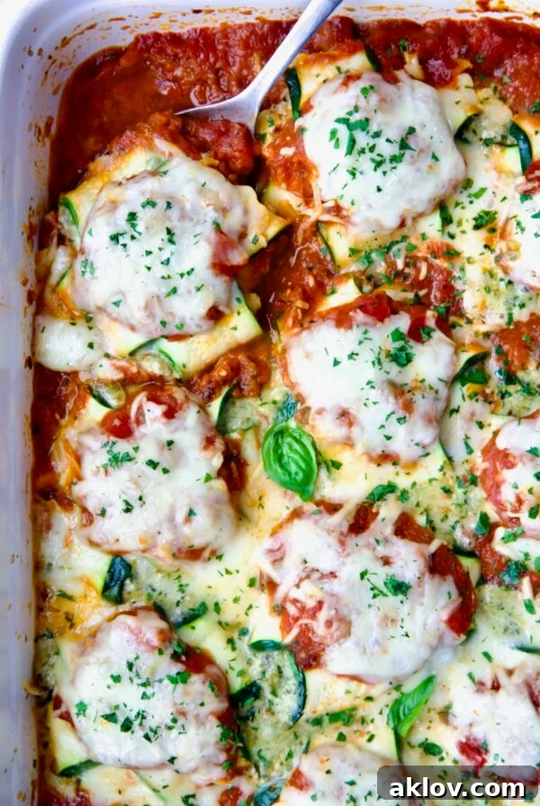Zucchini Ravioli in white baking dish with serving spoon.