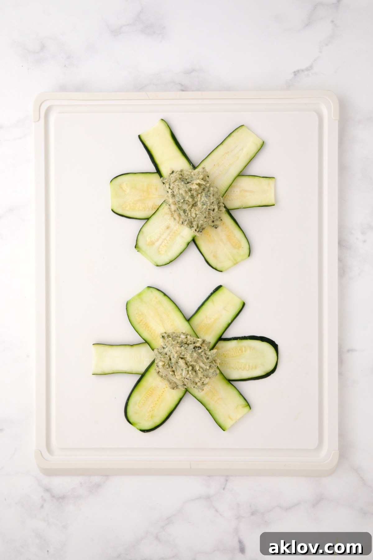 Two sets of zucchini slices in a star pattern with ricotta pesto filling in the center.