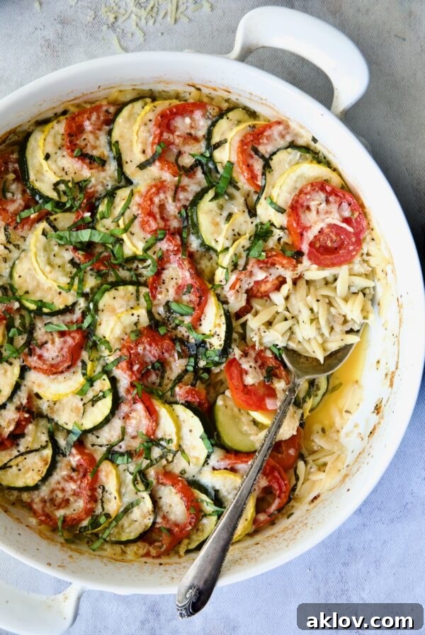 Orzo Vegetable Tian in round white baking dish with serving spoon.