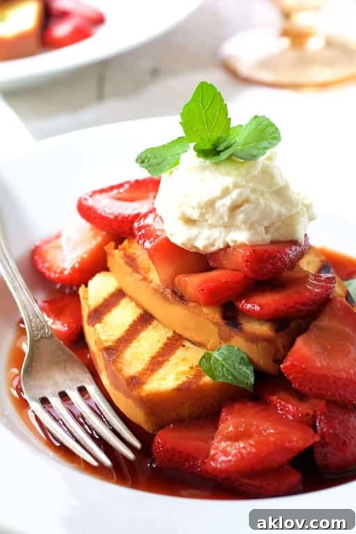 Photo of a beautifully plated Grilled Pound Cake with Balsamic Macerated Strawberries and Mascarpone Cream, elegantly garnished with a fresh mint sprig, ready to be enjoyed.