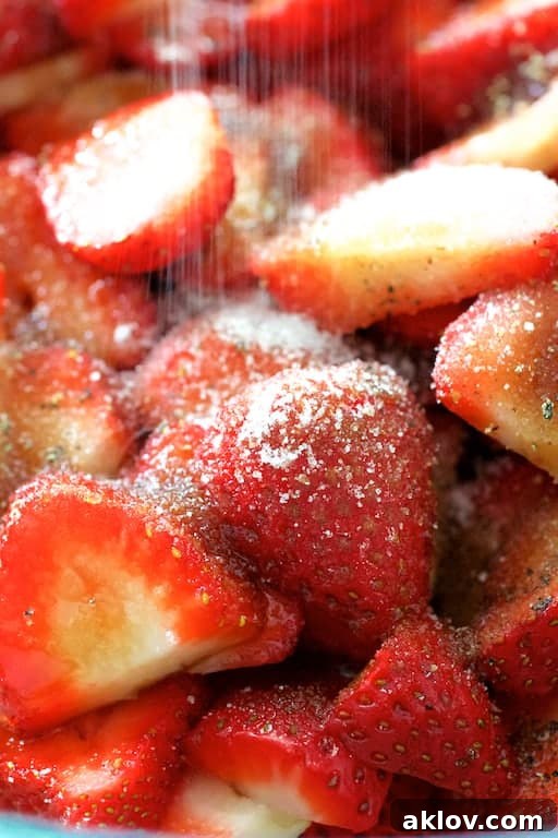 Close-up photo of strawberries being sprinkled with sugar.