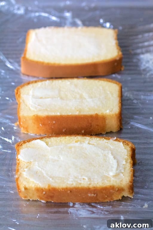 Photo of buttered pound cake slices on plastic wrap ready to be grilled.