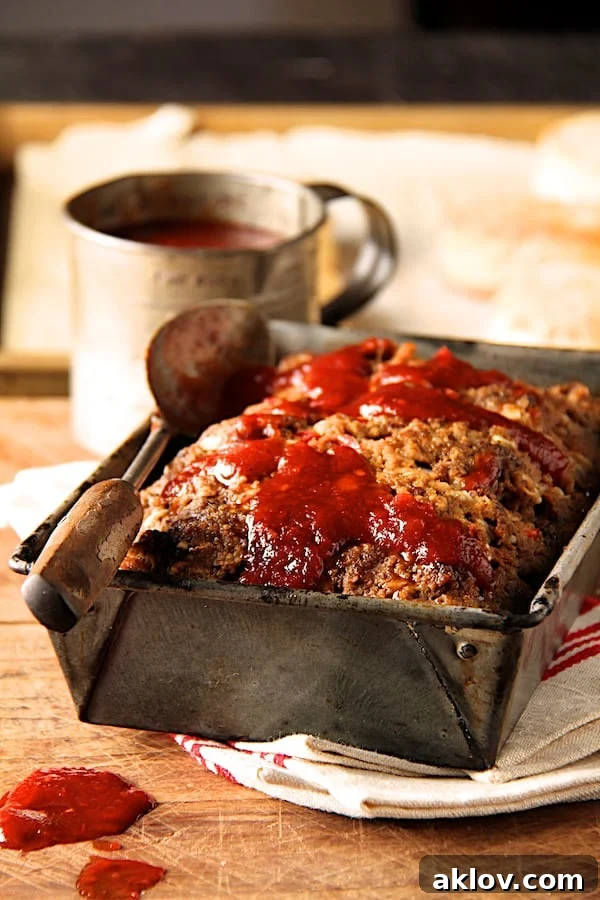 Photo of Chili-Glazed Meatloaf in aged metal pan with glaze.