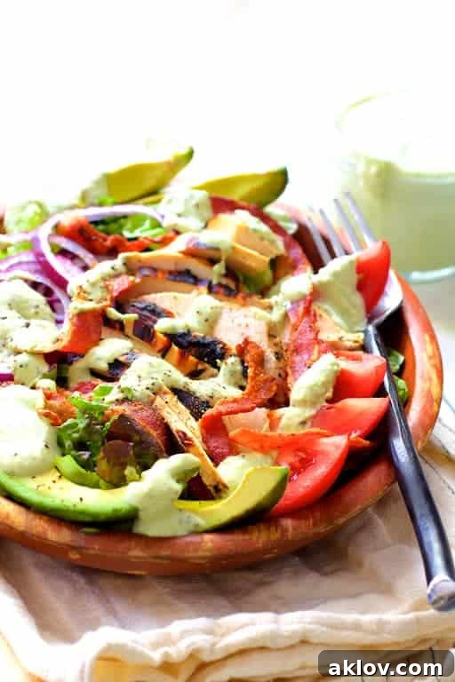 Chicken BLT Salad with Spicy Avocado Ranch Dressing in a rustic wood bowl, showcasing crisp lettuce, juicy tomatoes, golden chicken, and crunchy bacon.