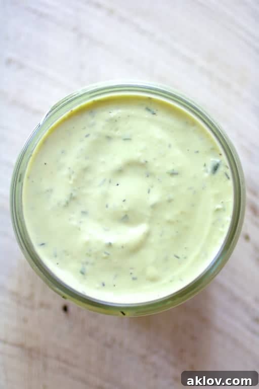 Spicy Avocado Ranch Dressing in a glass jar, showing its creamy, vibrant green texture.