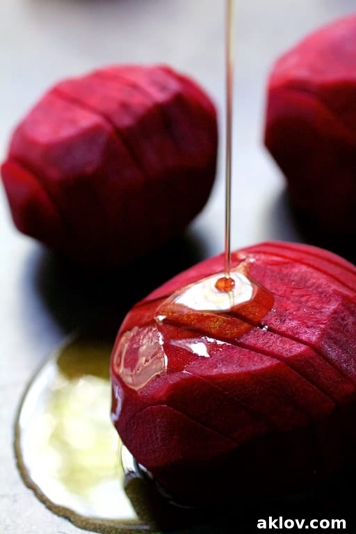 Photo of raw hasselbacked beets being drizzled with olive oil.