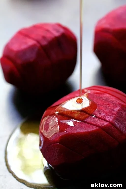 Fan-Cut Roasted Beets with Zesty Dill Dressing 6 Photo of raw hasselbacked beets being drizzled with olive oil.