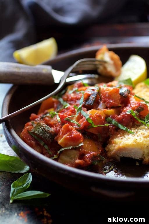 Photo of the ratatouille in clay dish with fork and knife.