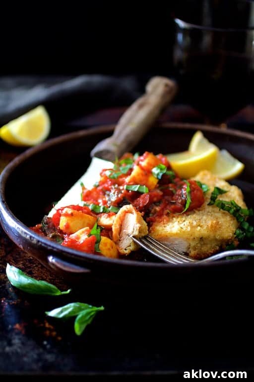 Photo of Chicken Scallopini with Roasted Vegetable Ratatouille in clay dish with a piece on a fork.