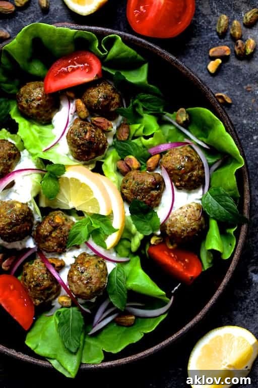 Photo of Turkish Turkey Meatball Lettuce Wraps with Tzatziki in clay dish with all the garnishes, close up.