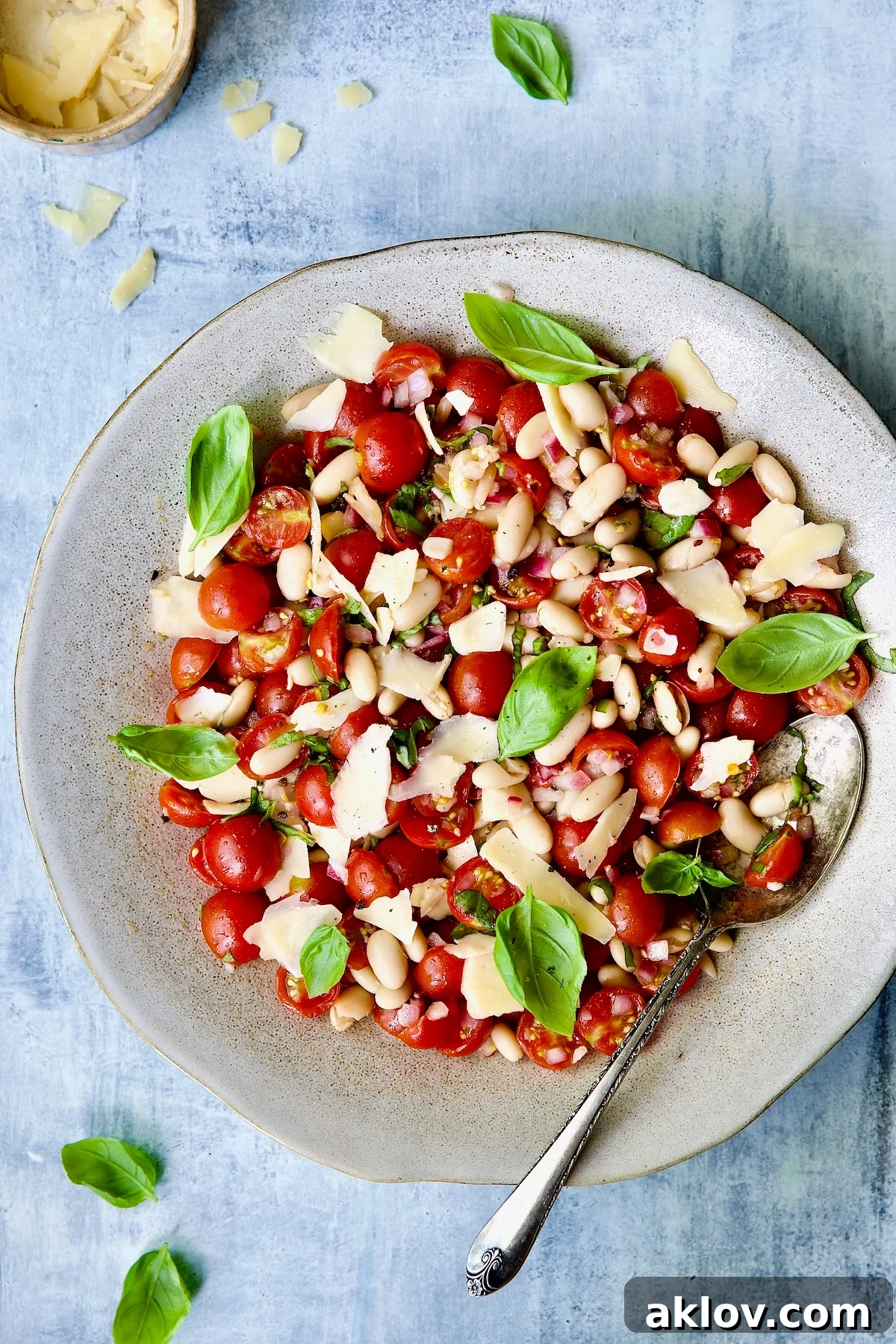 Tuscan Cherry Tomato and White Bean Salad in serving bowl garnished with fresh basil, ready to be served.