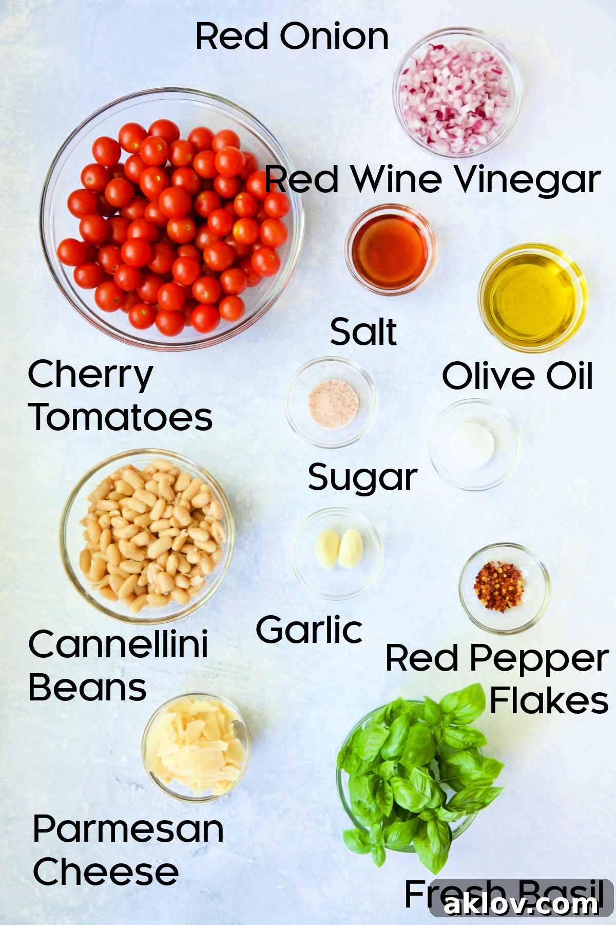 Ingredients for Tuscan Cherry Tomato and White Bean Salad laid out in glass bowls, ready for preparation.