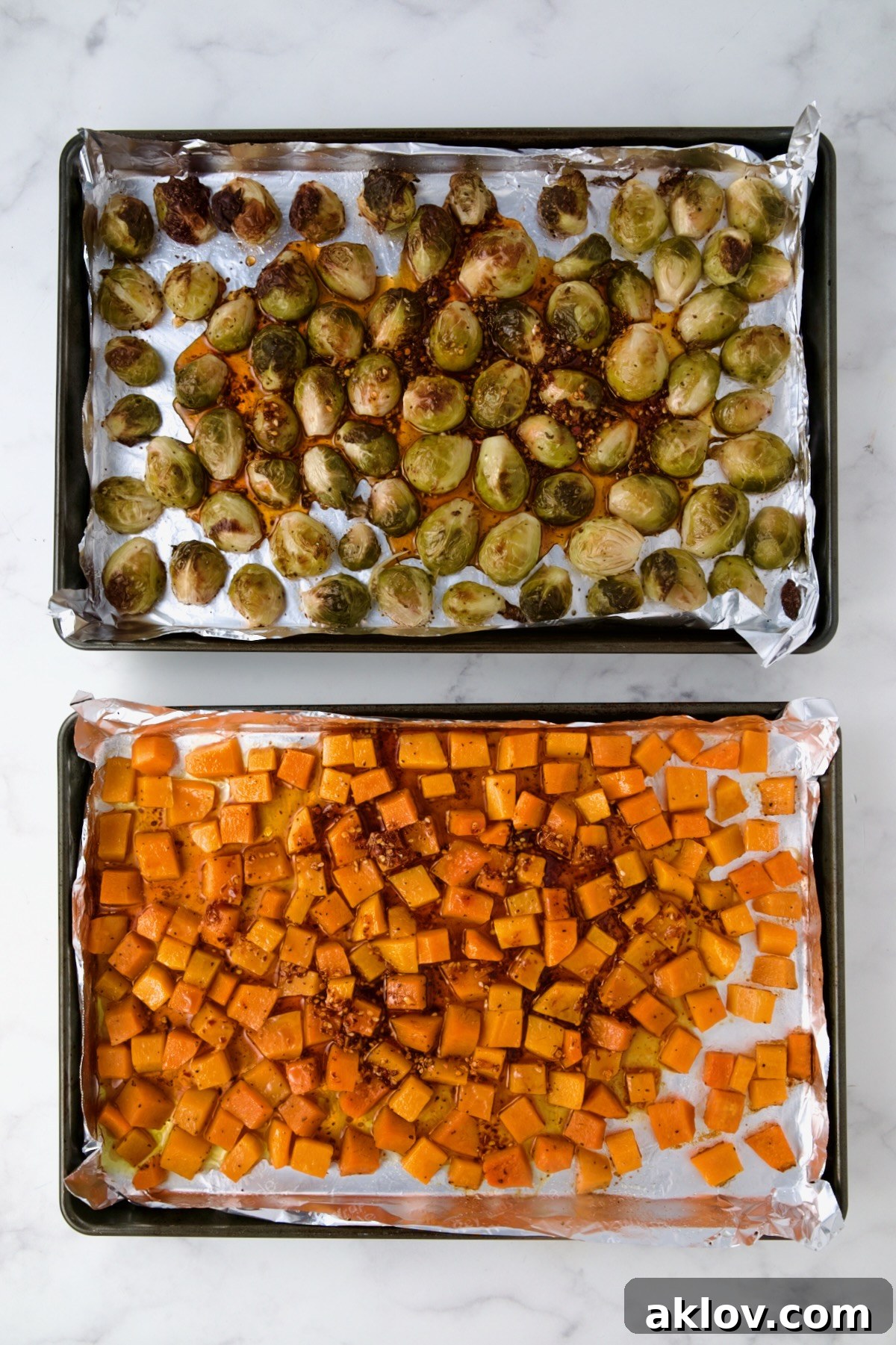The vibrant sauce is drizzled over the golden-roasted Brussels sprouts and butternut squash, still on their nonstick aluminum foil-lined baking sheets, ready to be combined and tossed.