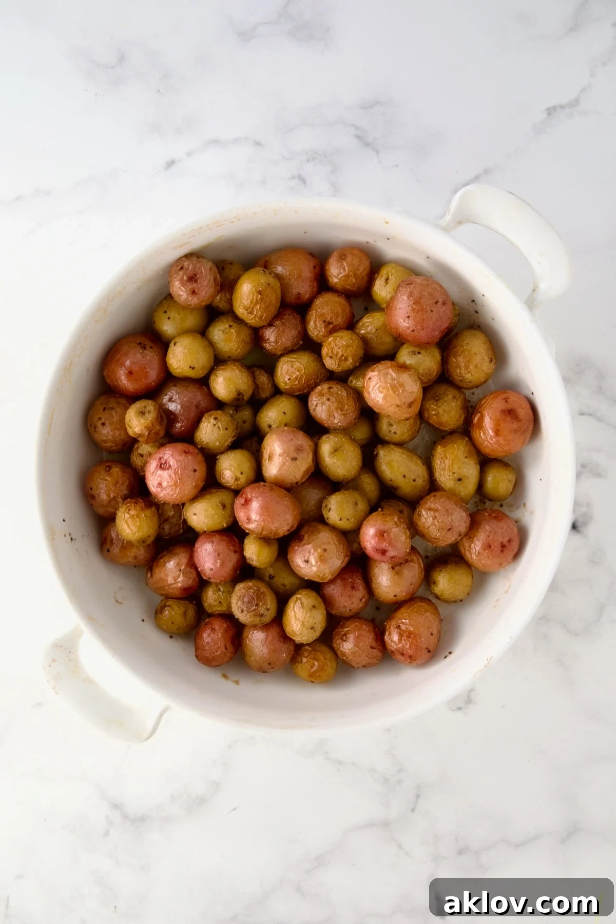 Roasted mini potatoes in round white baking dish.