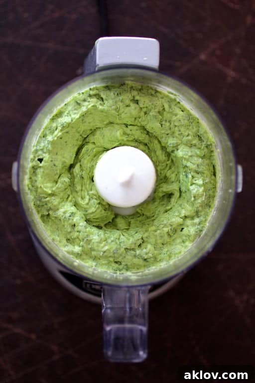 Smooth and creamy avocado butter freshly blended in a mini food processor, showcasing its vibrant green hue.