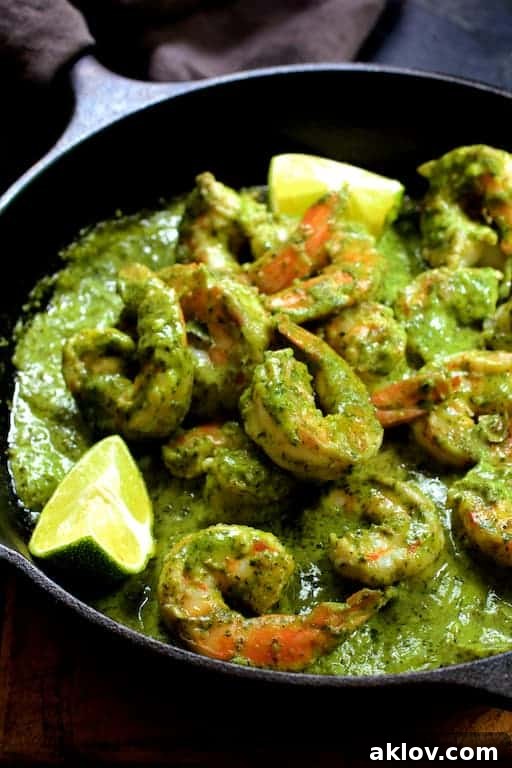 Sizzling shrimp cooked in a cast iron skillet, tossed and coated generously with melting avocado butter, ready to serve.