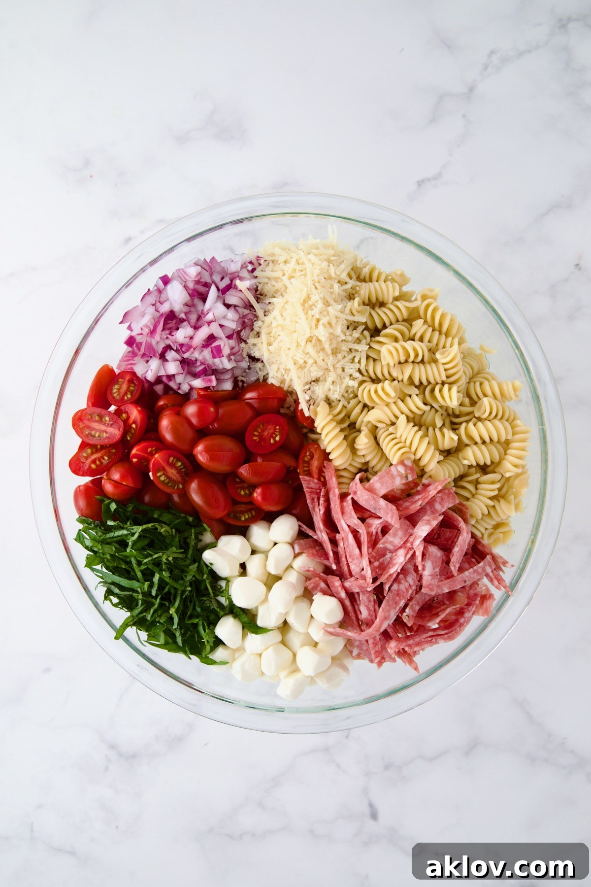 Ingredients for Caprese Pasta Salad in glass bowl before being combined.