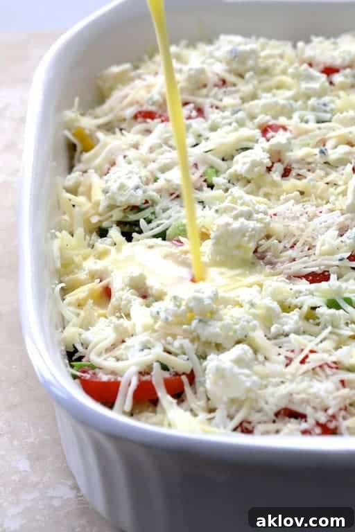 Photo of egg and milk mixture being poured over the layered ingredients in a strata before refrigeration and baking.