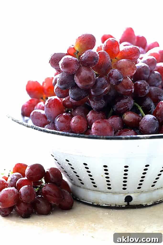 Photo of red grapes in antique white colander.