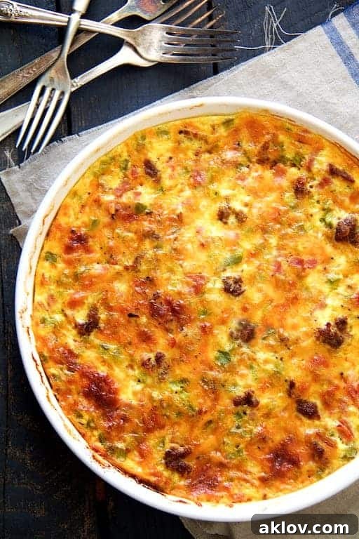 Photo of whole Crustless Quiche with Sausage Bacon and Ham on blue-striped napkin with four forks.