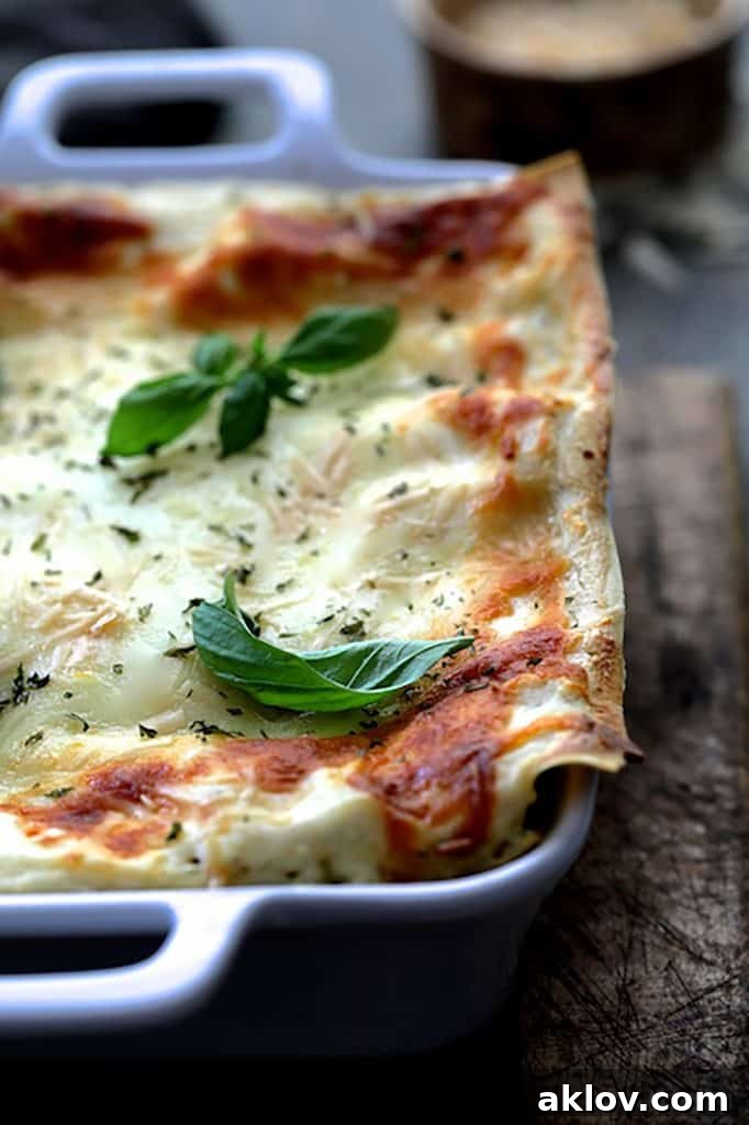 A detailed close-up shot of Lasagna with Pesto Green Beans and Potatoes in a white baking dish, showcasing its inviting texture.