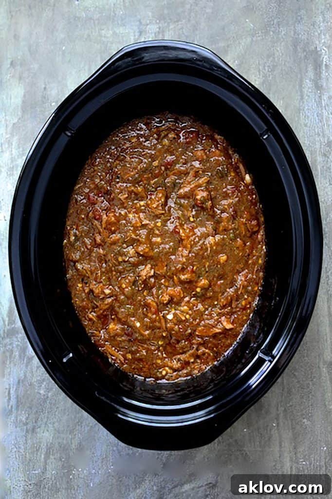 Photo of chili in slow cooker on gray background.