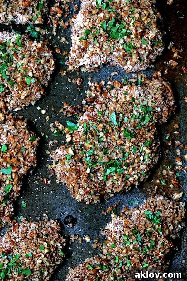 Pecan Crusted Turkey Medallions with Sweet Red Onion Marmalade 4 Close-up photo of Pecan Crusted Turkey Cutlets on baking sheet sprinkled with parsley.