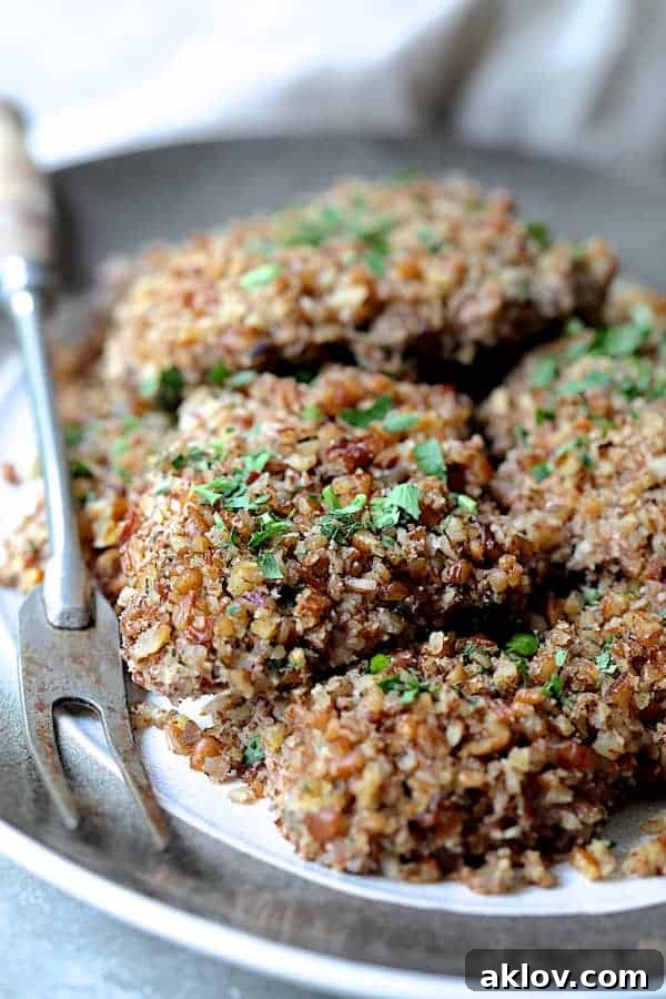 Pecan Crusted Turkey Medallions with Sweet Red Onion Marmalade 5 Photo of Pecan Crusted Turkey Cutlets on gray-rimmed platter with serving fork.