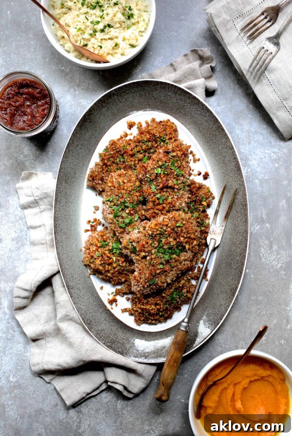 Pecan Crusted Turkey Cutlets with Red Onion Marmalade on oval gray-rimmed platter with meat fork.