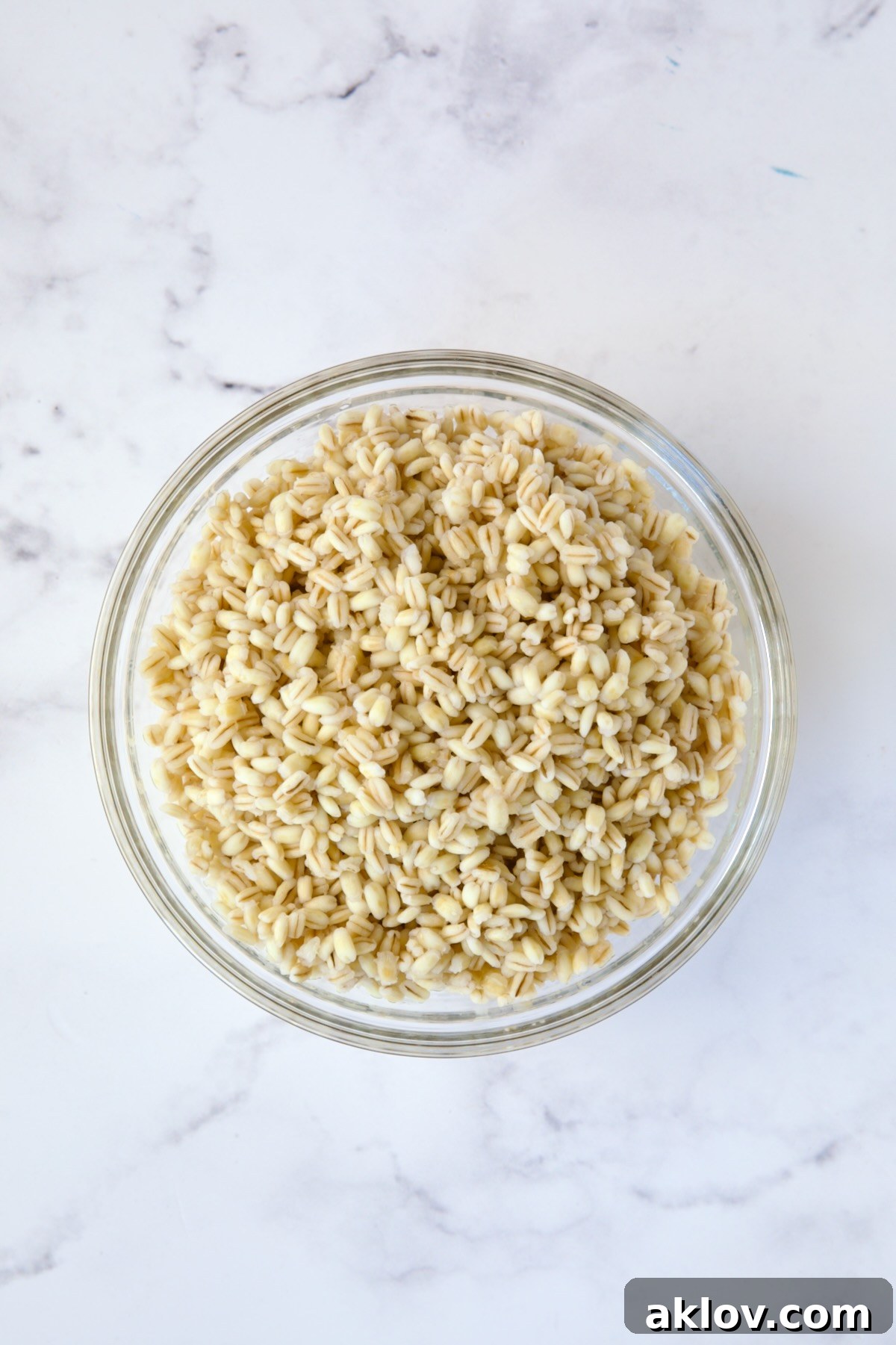 Perfectly cooked pearled barley resting in a clear glass bowl, showcasing its tender texture.