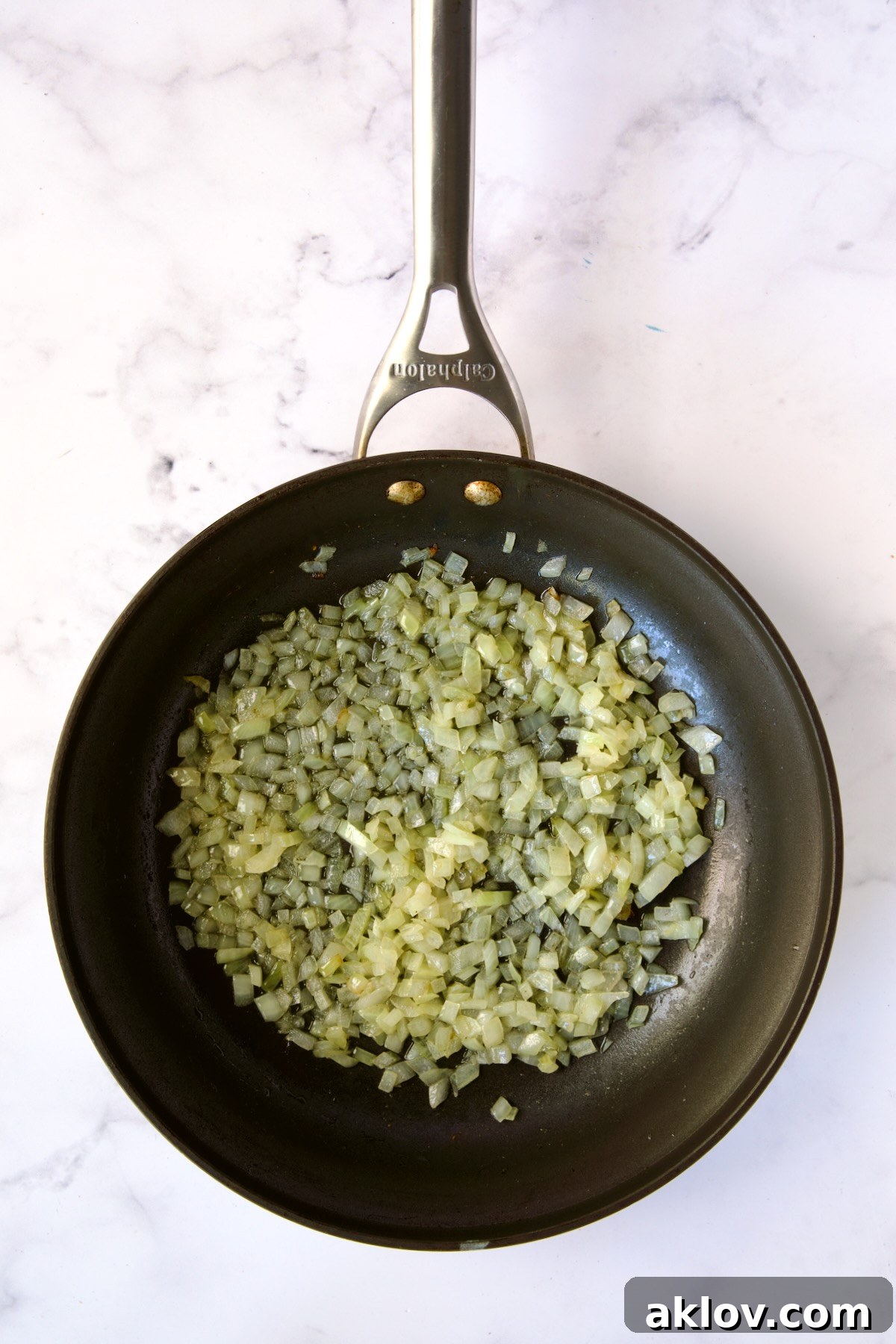 Finely diced onion cooking to translucent perfection in a nonstick skillet.