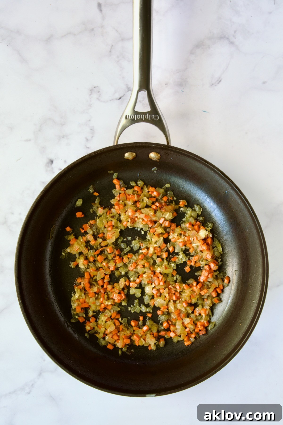 Sautéed diced onion and carrot mingling in a nonstick skillet, becoming soft and fragrant.