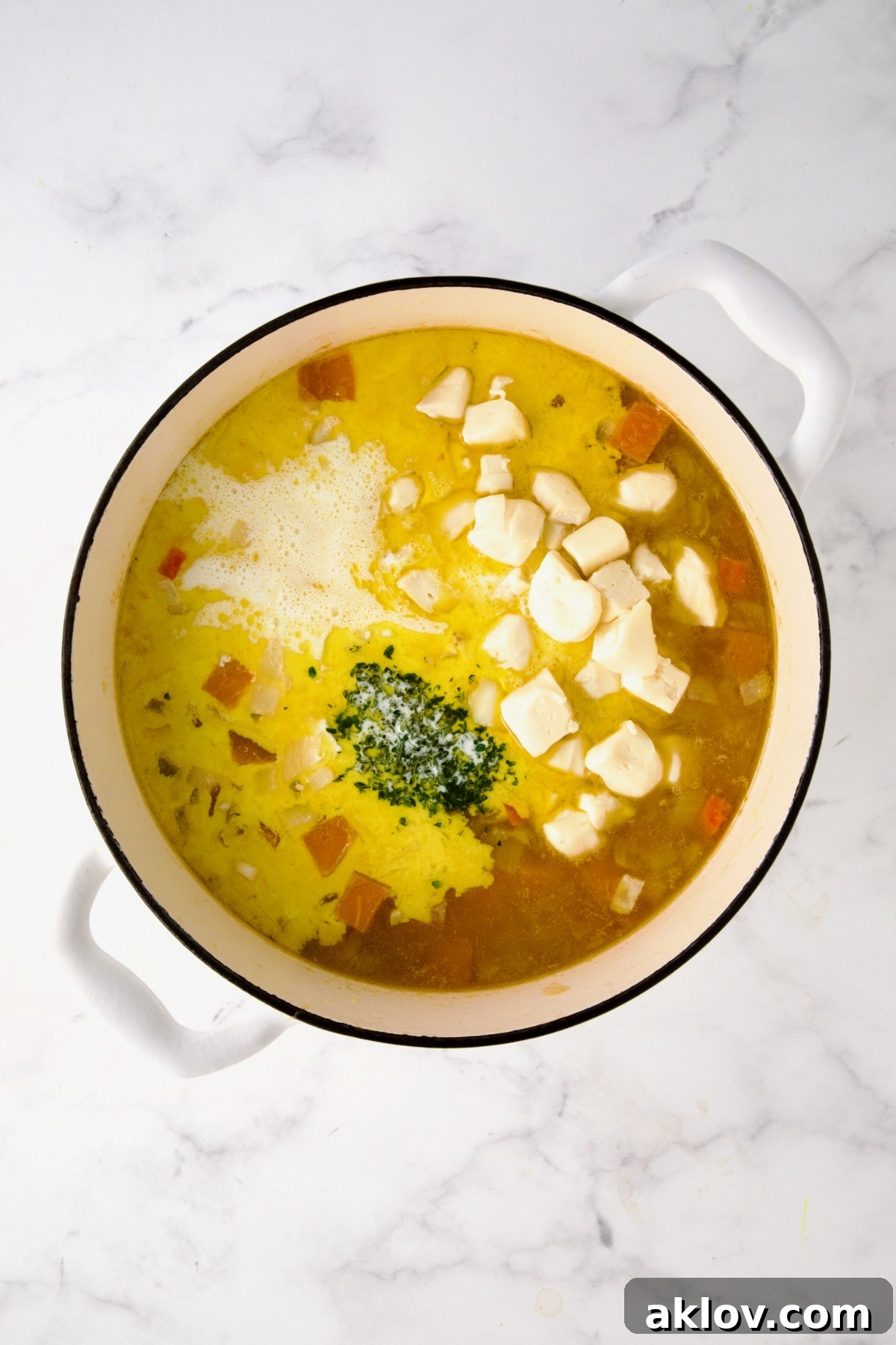 Fresh thyme, cubed Brie cheese (rind removed), and heavy cream added to the tender cooked butternut squash and vegetable mixture in the pot, just before blending.