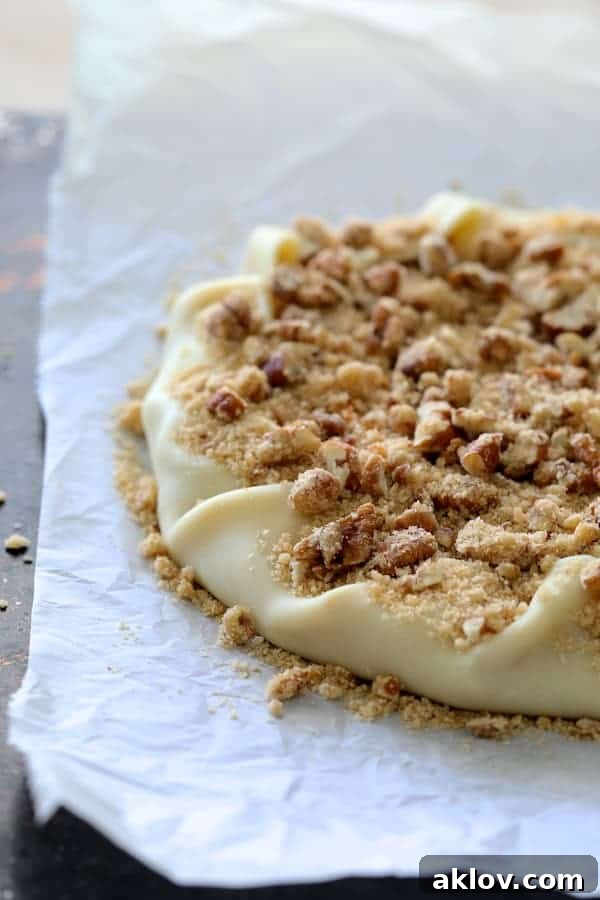 Process photo of galette with edges folded in topped with pecan streusel topping before being baked.
