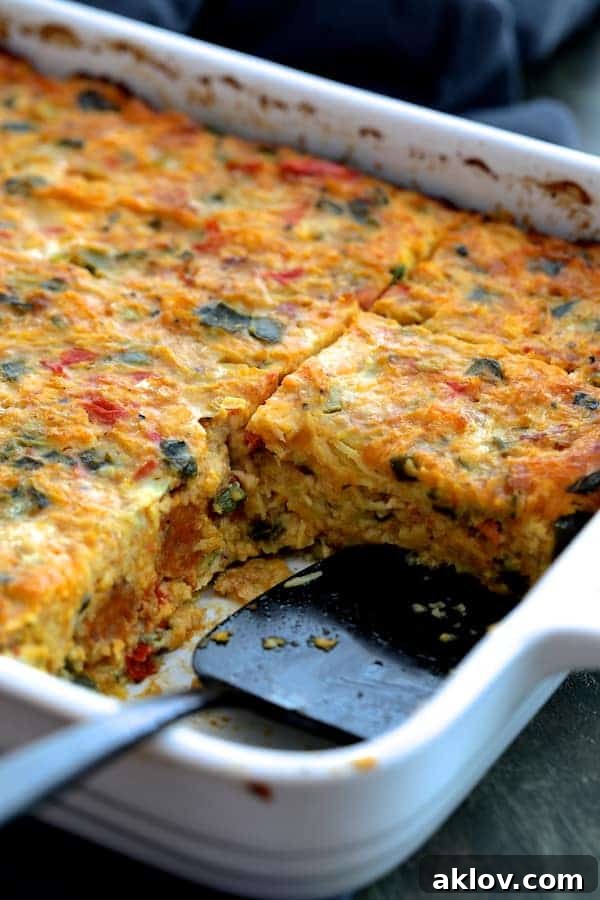 Photo of Spaghetti Squash Poblano and Chorizo Breakfast Casserole in white baking dish with pieces removed.