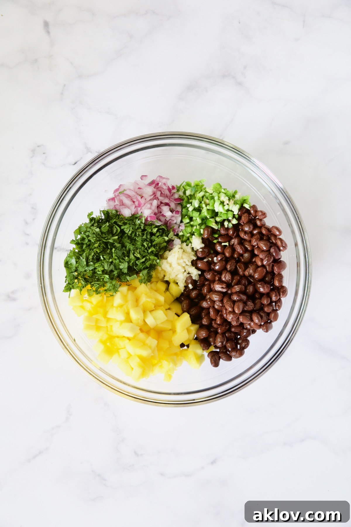 Ingredients for Black Bean Mango Salsa in glass bowl before being stirred.