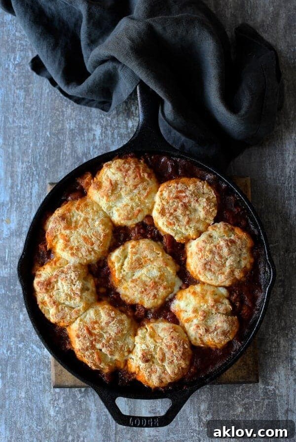 Skillet Turkey and Pinto Bean Chili with Pepper Jack Biscuit Topping in cast iron skillet with black napkin.