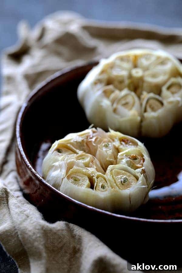 Heads of garlic roasting in a terracotta dish, infusing the kitchen with an aromatic fragrance.