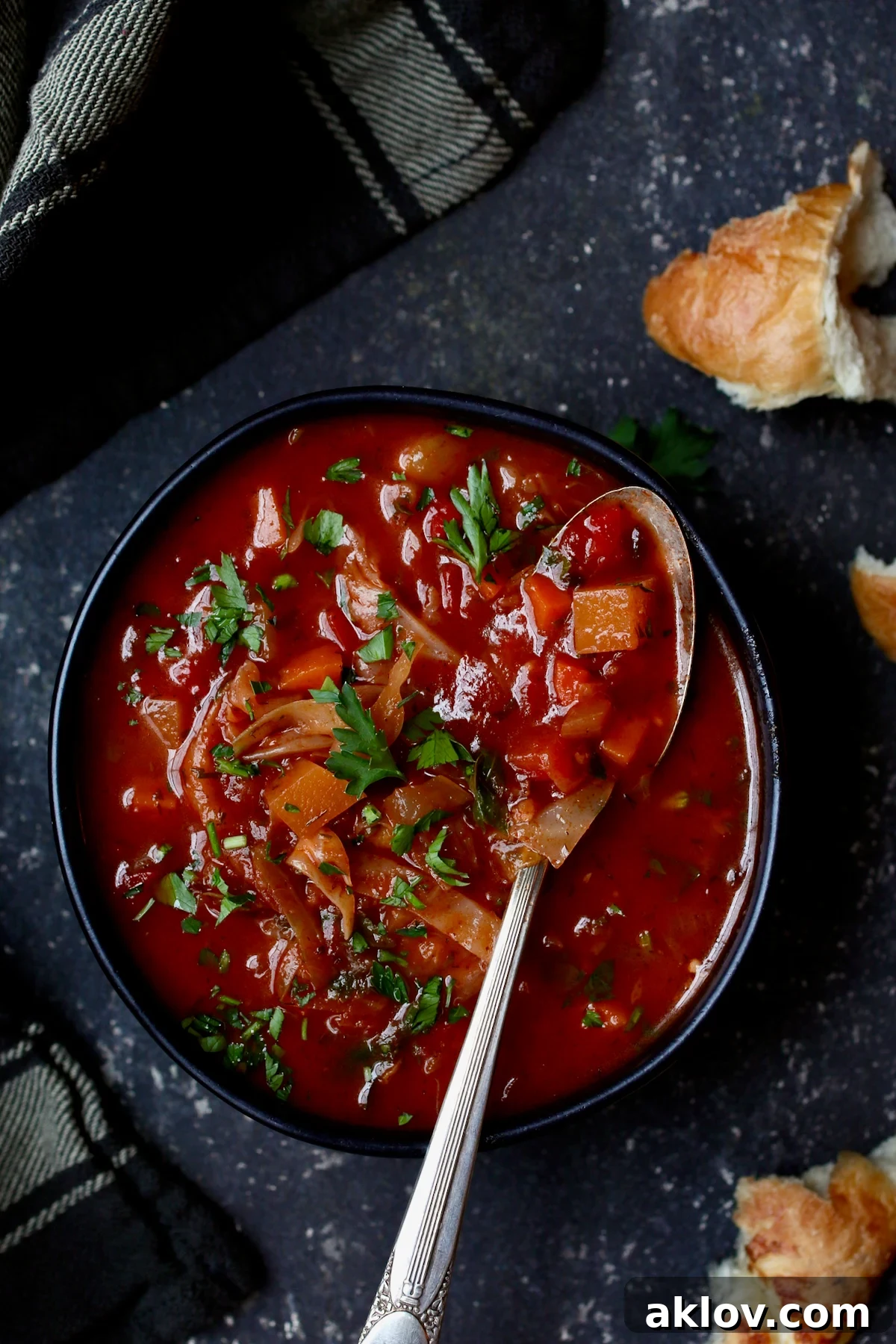 Rustic Cabbage and Root Vegetable Soup in a black bowl, garnished with fresh parsley.