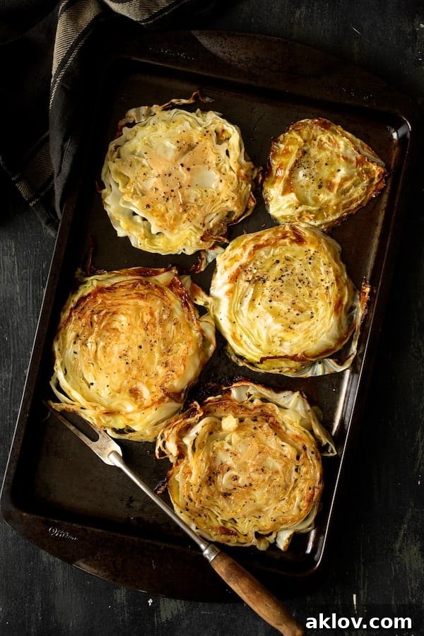Caramelized Cabbage Steaks with Tangy Dijon Dressing 4 Photo of five roasted cabbage steaks on baking sheet.