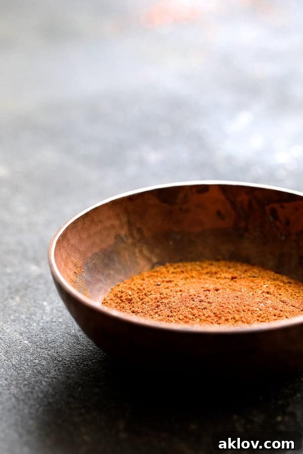 Masala-Crusted Sea Bass with Hearty Red Lentil Daal 4 A vibrant blend of Indian curry spices, including Hungarian paprika, cumin, coriander, and turmeric, sits in a polished copper bowl, ready to season the sea bass.
