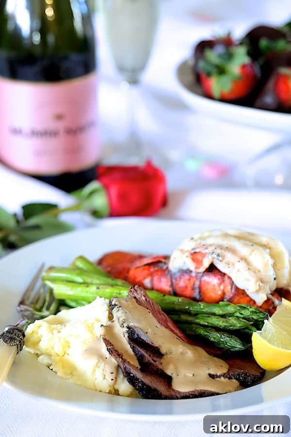 Photo of Steak au Poivre and Broiled Lobster Tail on white serving plate with asparagus.