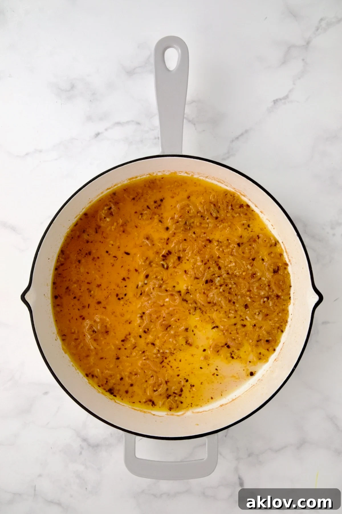 Deglazing the pan with white wine and lemon juice, creating a fragrant base for the scampi.