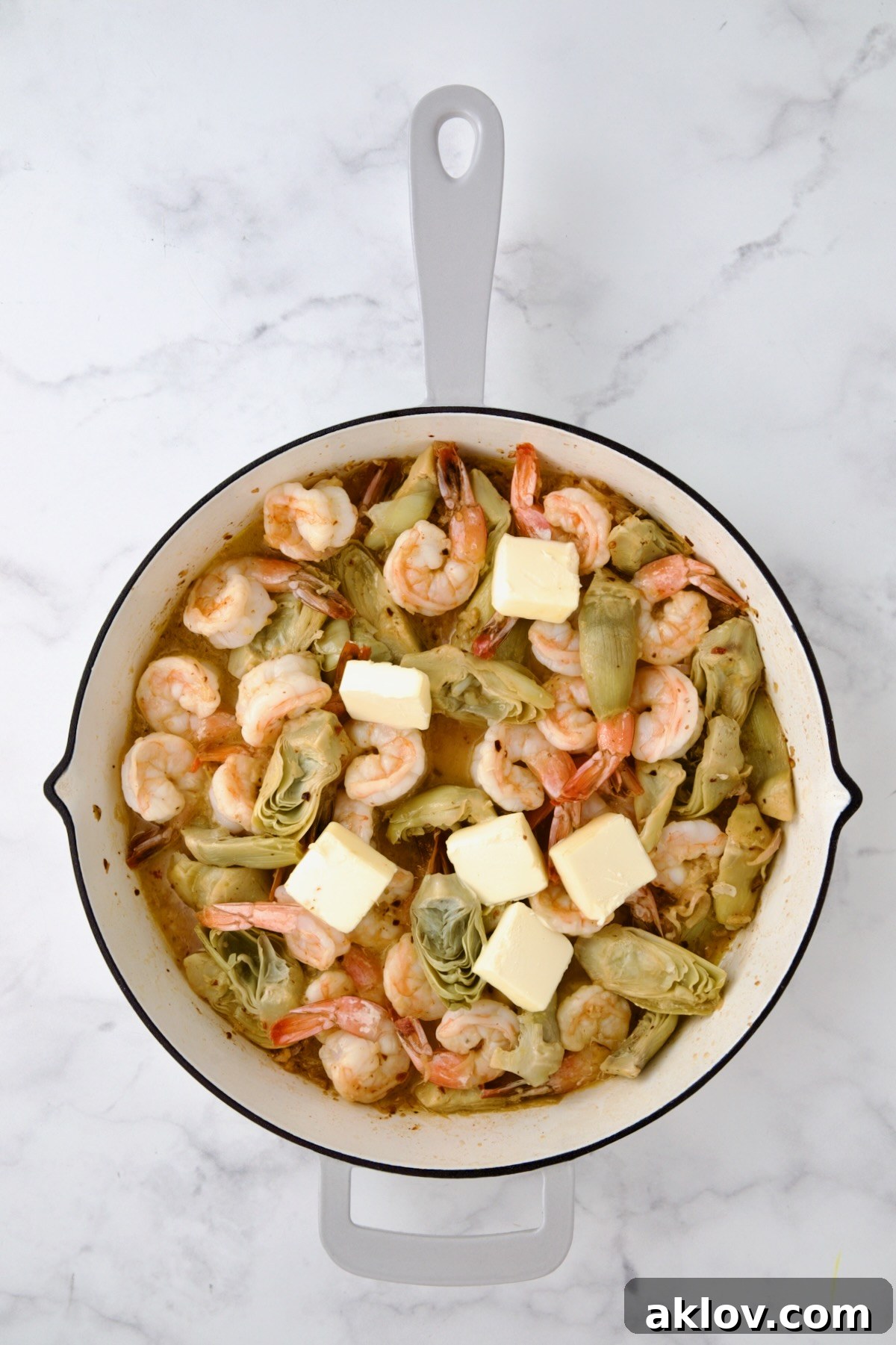 Rich butter melting into the finished Shrimp Scampi, creating a luxurious sauce.