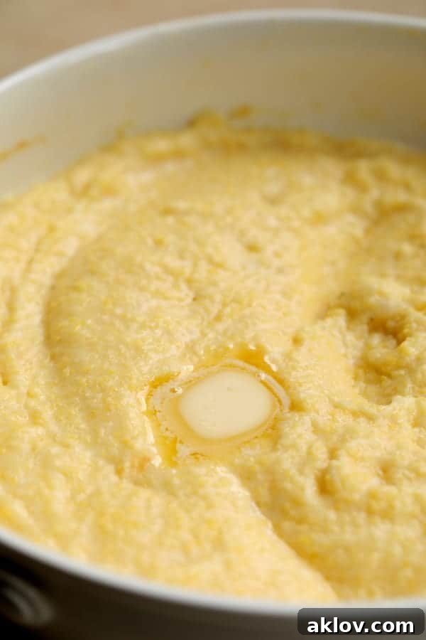 Creamy Parmesan Polenta with melting butter, showcasing its smooth texture.
