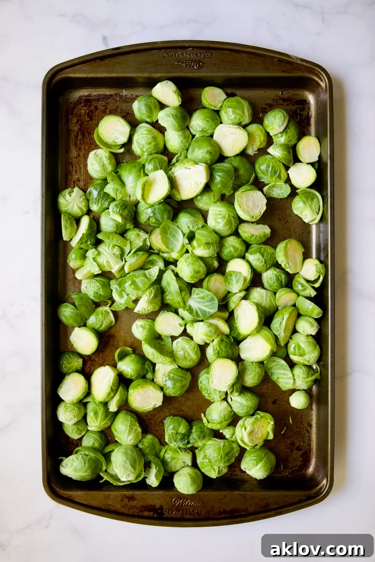 Glazed Sriracha Sweet Chili Brussels Sprouts 5 Halved Brussels sprouts spread on a baking sheet before any seasoning or roasting.