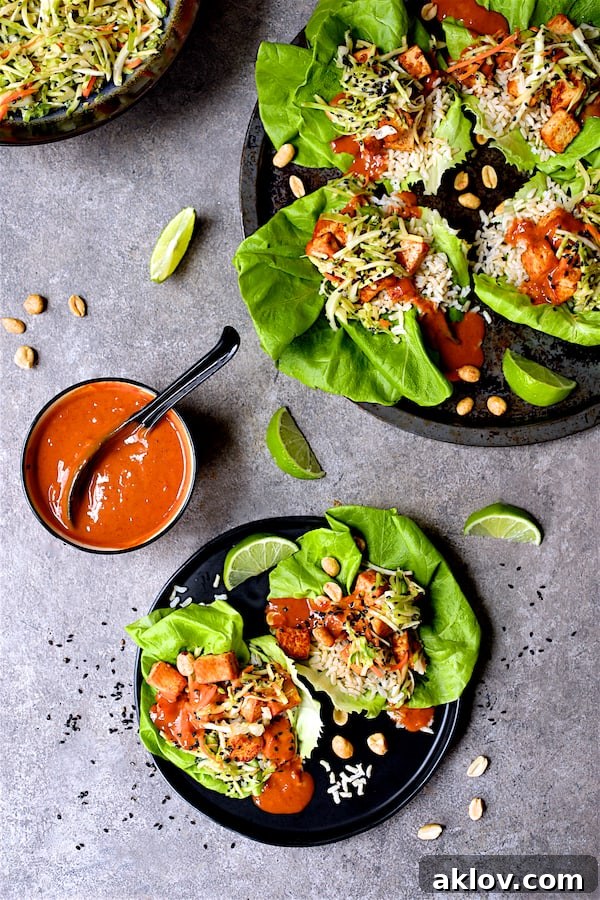 A platter of Vegan Korean Tofu Lettuce Wraps with Tahini Gochujang Sauce, alongside individual plates with lime wedges, ready to be enjoyed.